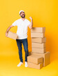 © luismolinero - Full-length shot of delivery man among boxes over isolated yellow background celebrating a victory