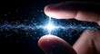 © Kabir Design - A human thumb and index finger holding a bright glowing spark of digital energy and data particles