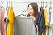 © KMPZZZ - Choice of clothes,Nothing to wear. Attractive asian young woman, girl try on appare, happy choosing dress, outfit on hanger in wardrobe in room closet at home. Deciding blouse what to put on which one