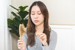 © KMPZZZ - Damaged hair, amazed asian young woman, girl hand holding brush comb, hairbrush with fall hair from scalp after brushing, female worry about balding. Health care, beauty treatment, hair loss problem