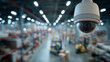 © Dionisia - White dome CCTV camera inside large warehouse with blurred storage shelves and logistics activity, modern indoor surveillance security monitoring concept