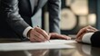 © spyrakot - Professional consultation with client signing documents in modern office setting