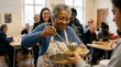 © tati_vision - Elderly woman serving soup to volunteers in community kitchen