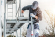 © Tomasz Zajda - Worker Sets up Scaffolding for Construction Task