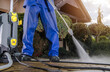 © Tomasz Zajda - Man Cleans Patio With Pressure Washer on Sunny Day