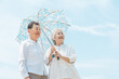 © buritora - An elderly couple, a married couple, a man and a woman using parasols under a blue sky (for protection against UV rays and heatstroke).