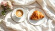 © Unplanned_Pixel - Enjoying a quiet morning with steaming coffee and crispy croissants on a minimalist white linen surface.