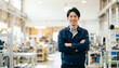 © Yka - 工場の通路で腕組みをして微笑む男性作業員