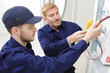 © auremar - electrician checking voltage of fuse board