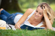 © auremar - beautiful young girl with a book lying on the grass
