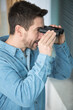 © auremar - guy looking through window using binoculars