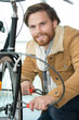 © auremar - young man repairing bicycle