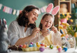 © Konstantin Yuganov - Happy Mother and Daughter Painting Easter Eggs Together at Home