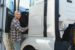 © Serhii - Truck driver smiling while entering cabin of semi truck