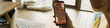 © DragonImages - Header of Caucasian middle aged woman holding smartphone displaying mulled wine recipe, sitting indoors near window with sunlight streaming in, right hand gripping device, partial face visible