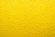 © Ame - Fruit skin surface made of citrus peel in bright yellow tones with a porous pitted texture in a full frame macro.