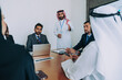 © oneinchpunch - Middle eastern businessman discussing ideas with multiethnic corporate team