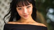 © swillklitch - Young woman with long wavy brown hair in strapless black top standing outdoors against soft tree background in warm autumn light