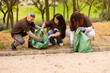 © ADDICTIVE STOCK - Multiethnic friends participating in city cleanup