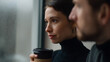 © A2Z AI  - Woman hold hot drink near rainy window with man beside her. Thoughtful female look at the cityscape in contemplation with a friend