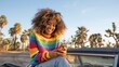 © Iryna - African female young smiling colorful sweater car palms outdoor sitting with phone sunset light