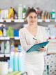 © JackF - Young woman seller with folder conducting inventory in household chemicals store