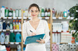 © JackF - Young woman seller with folder conducting inventory in household chemicals store