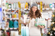 © JackF - Young female shopper buying gift set of care products in household chemicals store decorated for christmas