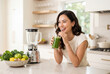 © Meow Creations - Young woman drinking a fresh green smoothie in a kitchen