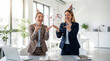 © Pei - April Fools Day businesswomen colleagues party hats confetti laughing celebration office teamwork joy fun workplace corporate marketing social media
