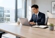 © husni - Professional Asian Businessman Working on Laptop in Modern Minimalist Office with Natural Light and Copy Space