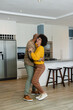 © Wavebreak Media - African American couple dancing and embracing in modern kitchen with stainless steel refrigerator