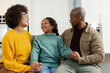 © Wavebreak Media - Diverse family wearing knit sweaters holding hands and smiling in kitchen near stainless steel oven