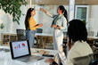 © Wavebreak Media - Diverse coworkers discussing digital marketing on glass whiteboard with laptop in conference room