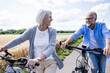 © Westend61 - Smiling couple cycling outdoors on rural road in summer