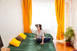 © _KUBE_ - Woman engaged in digital experiences using VR headset on her bed, testing cutting-edge graphics. Top view, wide shot