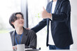 © kapinon - 会社の仕事中に上司に励まされる新卒などの新入社員の爽やかなイメージ　その調子！仕事頑張ってね！OJTで先輩に指導を受ける若手社員の成長と教育のビジネスシーン