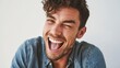 © 4kclips - Showcasing authenticity and joyful expression a man is captured laughing with genuine emotion He is winking and smiling while wearing a denim shirt against a white background representing happiness.
