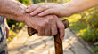 © Aurora Aesthetics - Adult hand comforting wrinkled senior hand gripping walking stick outdoors concept of geriatric physical support family empathy mobility assistance and intergenerational care