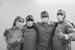 © Sabrina - Happy medical team smiling in front of camera while wearing hazmat suit and protective masks inside hospital corridor - Teamwork, multiracial people and medicine concept - Black and white editing
