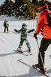 © BGStock72 - Child learning to ski with instructor on snowy slope at winter resort in daytime