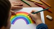 © Eve - Close up of child hand drawing colorful rainbow with pencils on paper. Preschool education, creative development and childhood art. Bright colors, hope and happiness concept for school ads.