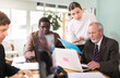 © JackF - Woman with documents is standing next to senior male colleague with laptop, working together, coordinating project, and making collective proposal.