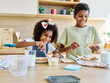 © Lumos sp - Portret of brother and sister having fun together preparing sanwiches snack for  breakfast and school  in kitchen