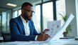 © miss irine - Man in suit reviews financial charts, graphs at bright office desk. Analyzes business data reports, planning strategy, working on project. Pro male employee checks company performance, growth metrics.