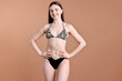 © New Africa - Beautiful young woman wearing stylish bikini on brown background