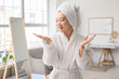 © Pixel-Shot - Beautiful young happy Asian woman in bathrobe with cleansing foam at home