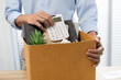© Charlie's - Business man sending resignation letter and packing Stuff Resign Depress or carrying business cardboard box by desk in office. Change of job or fired from company