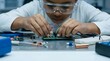 © SITI - Focused young African American boy wearing safety goggles working on an electronics STEM project