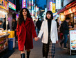 © Abhi - Two women — holding hands walking in Tokyo street, vibrant city evening